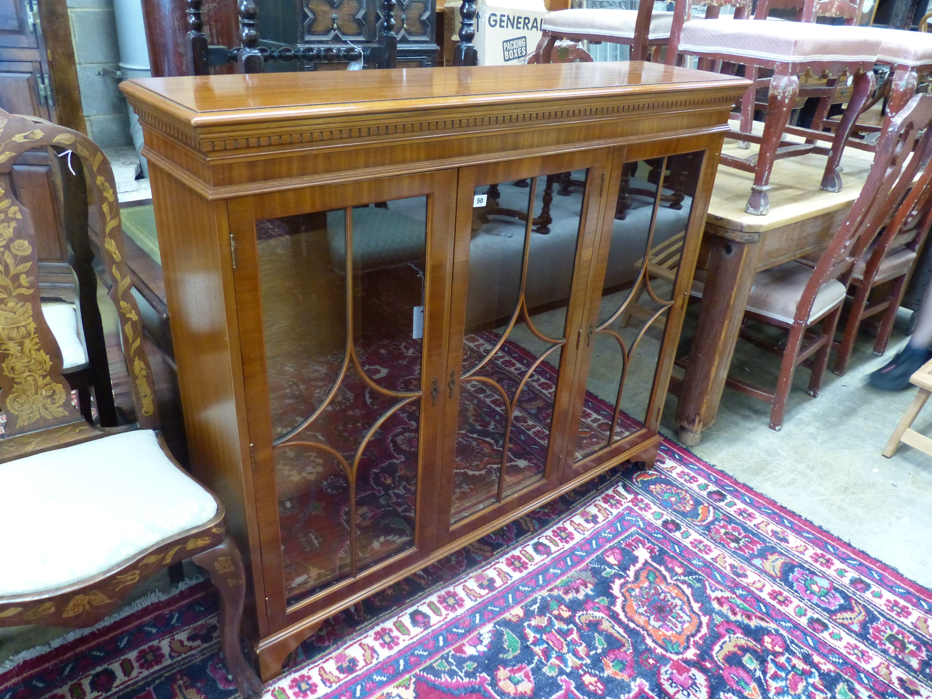A reproduction mahogany three door bookcase, width 135cm depth 33cm height 116cm